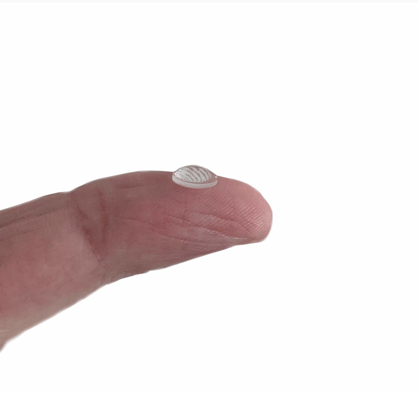 A single mini domed bumper on a mans fingertip to indicate just how small the product is.
