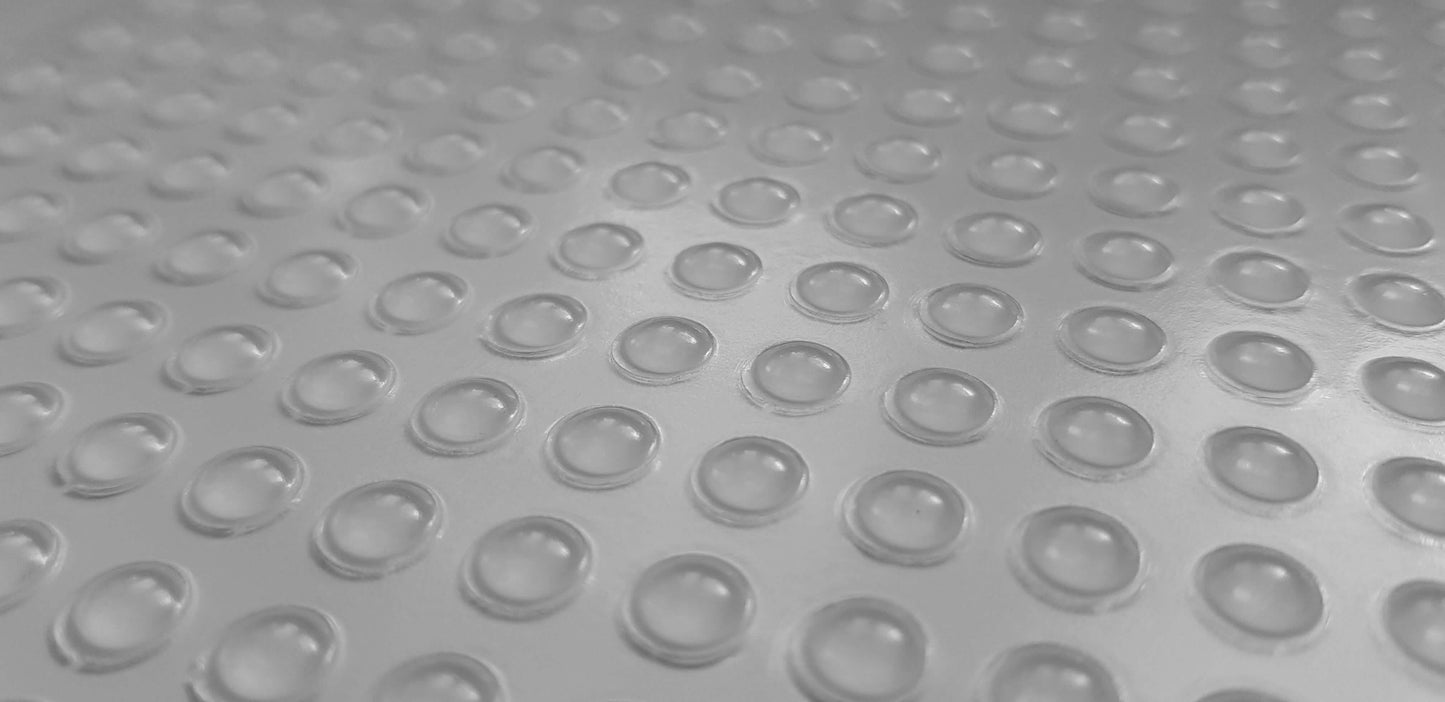 A sheet of adhesive backed domed mini bumper feet.
