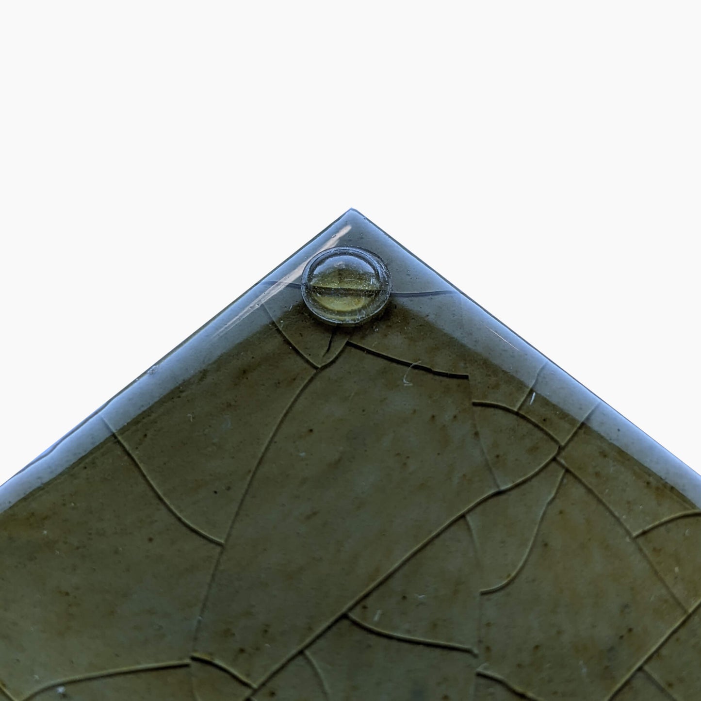 A single domed mini size bumper dot used on a glazed ceramic tile.