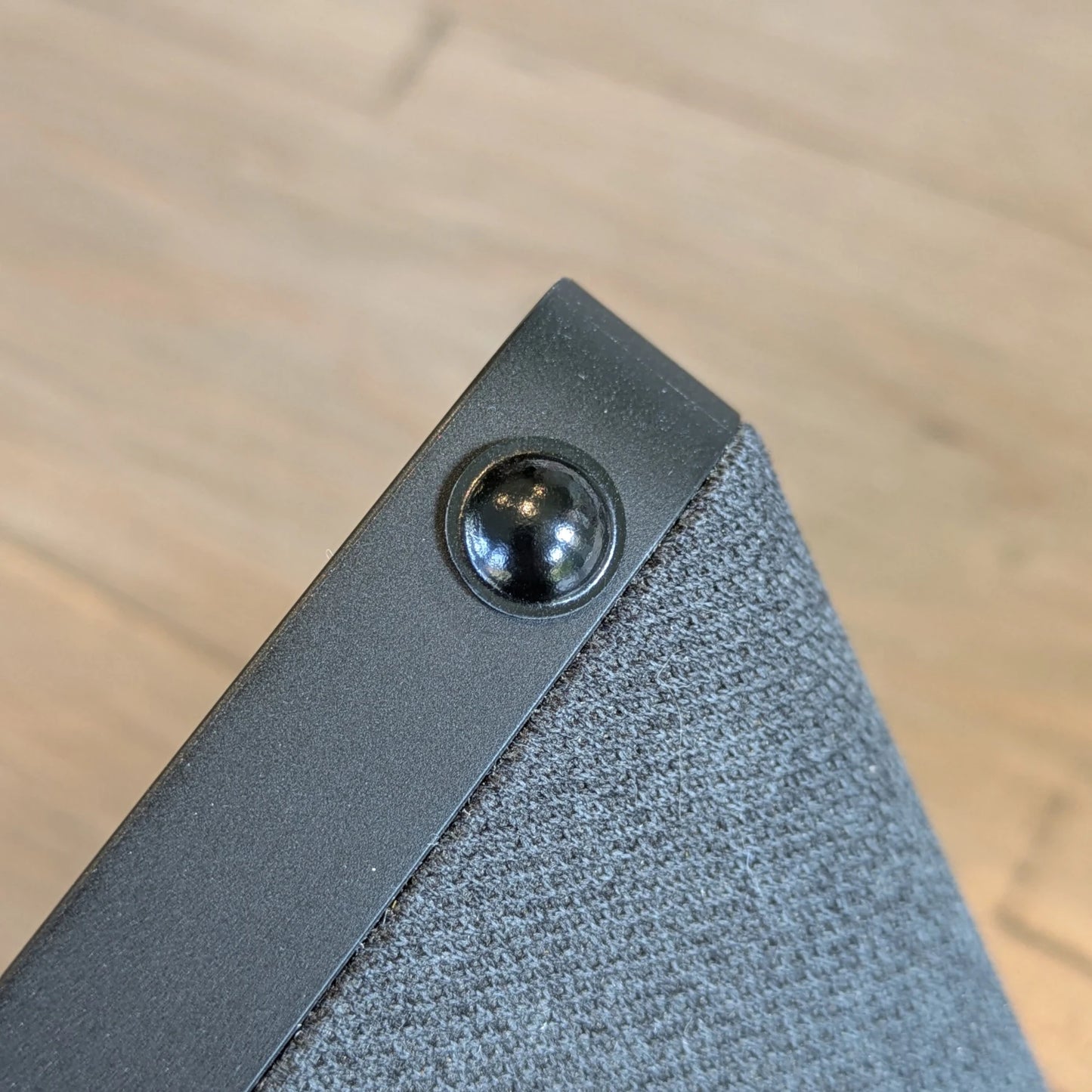 A domed black bumper foot used on a portable speaker unit to provide stability.