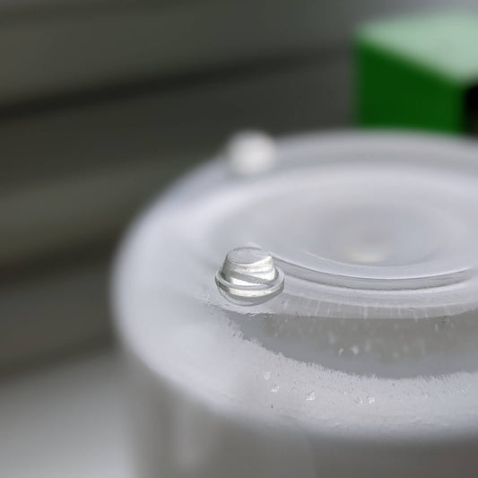 Mini clear flat topped feet adhered to the base of glass candle jar.