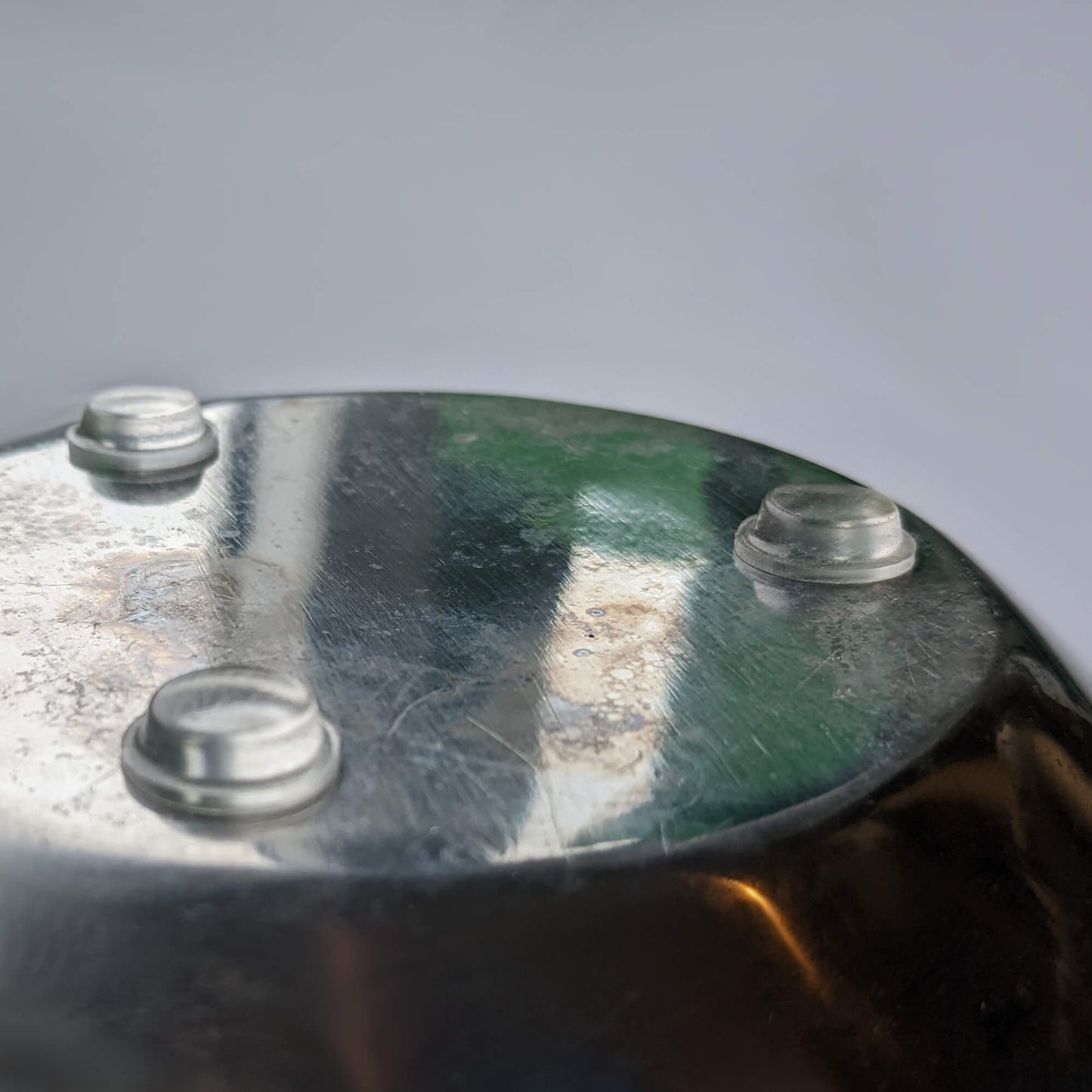 3 clear flat bumper pads being used on the base of a galvanized metal bowl.