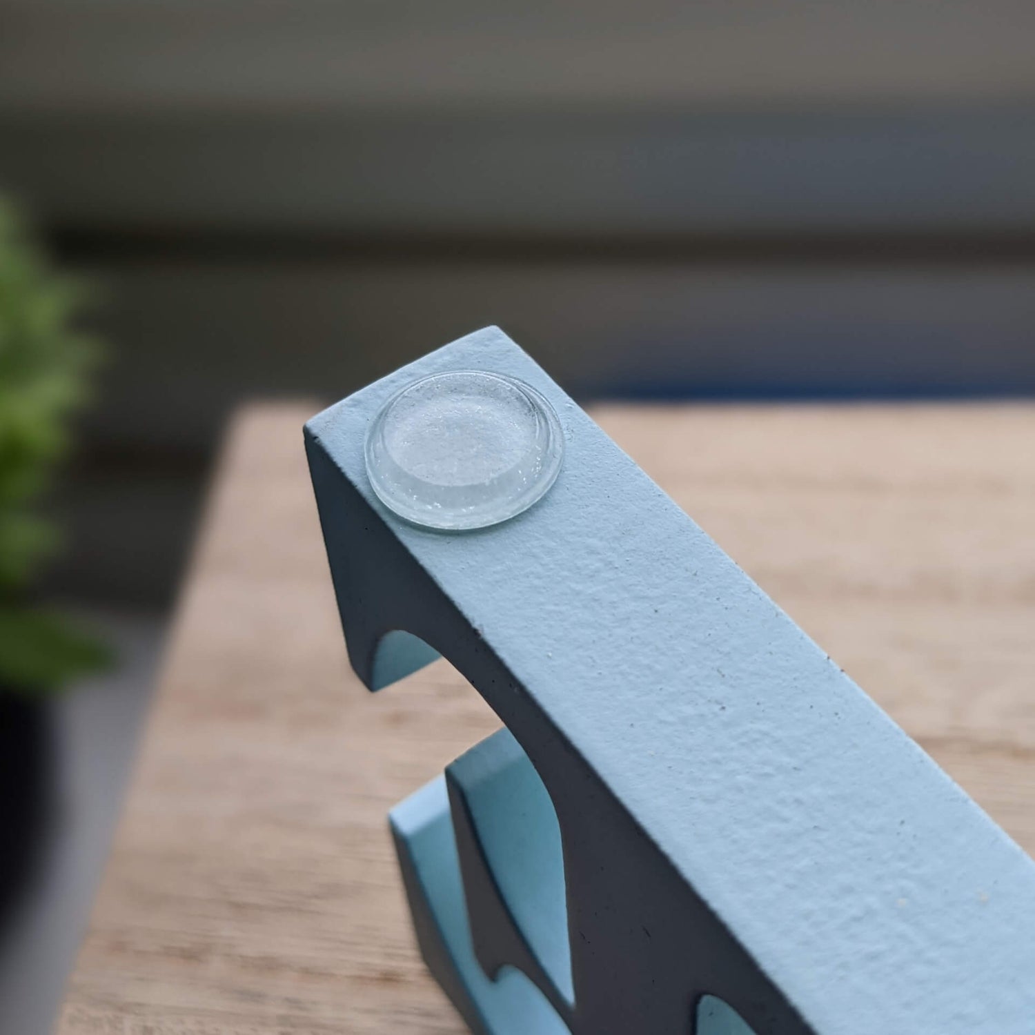 A clear flat bumper pad used on the base of a painted decoration.