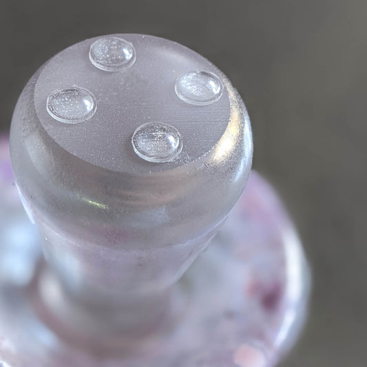 4 mini domed bumper feet in clear, being used on the base of a glass ornament, shaped like a mushroom.