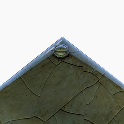 A single domed mini size bumper dot used on a glazed ceramic tile.