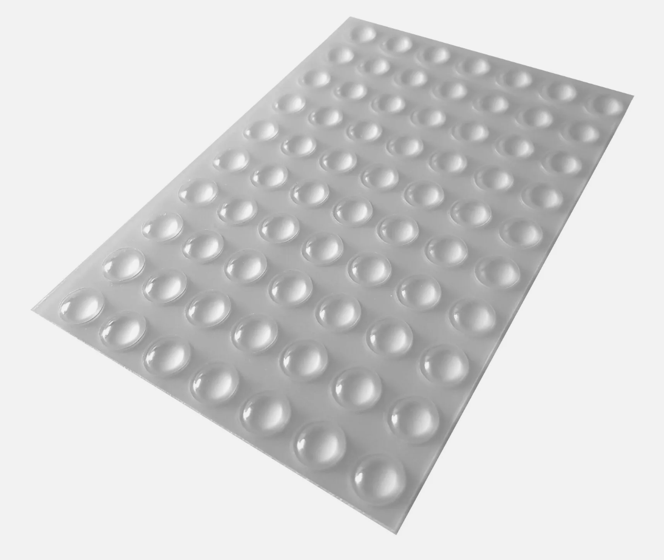 An adhesive backed sheet of seventy clear domed bumper feet.
