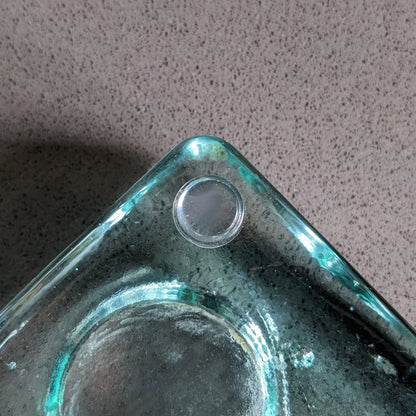 A single clear flat topped bumper stuck to the bottom corner of a tealight holder.