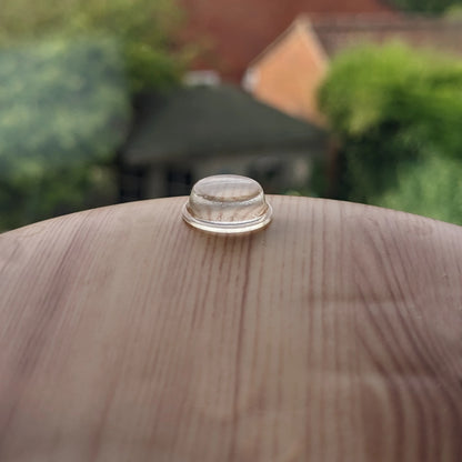 A single flat topped bumper foot used on the base of a plastic wood effect electronic unit.