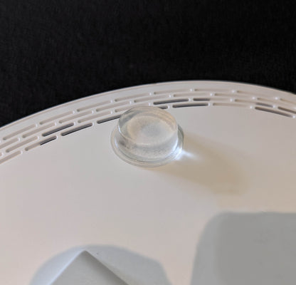 A clear flat bumper foot applied to the base of an electronic unit.