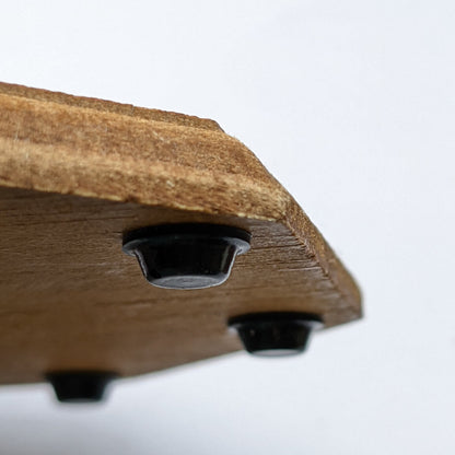 3 mini sized black bumper feet used on the base of a wooden coaster to prevent slipping and sliding.