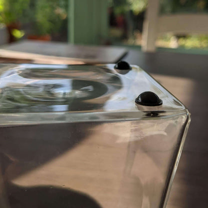 2 domed black bumper feet applied to the base of a glass vase.