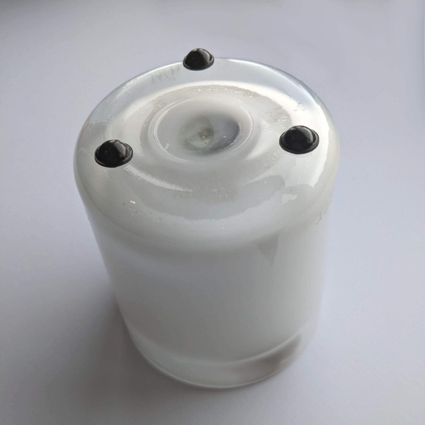 3 domed bumper feet in black finish being used on the bottom of a glass candle jar.