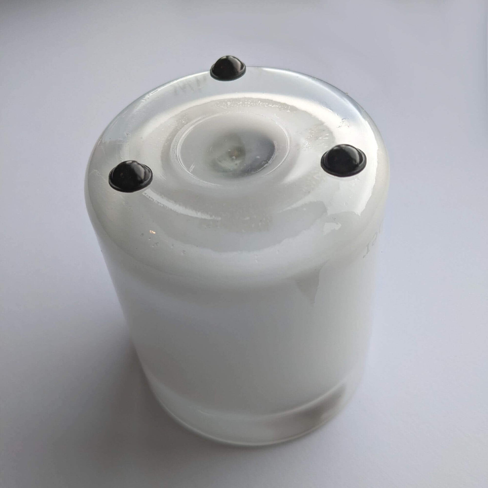 3 domed bumper feet in black finish being used on the bottom of a glass candle jar.