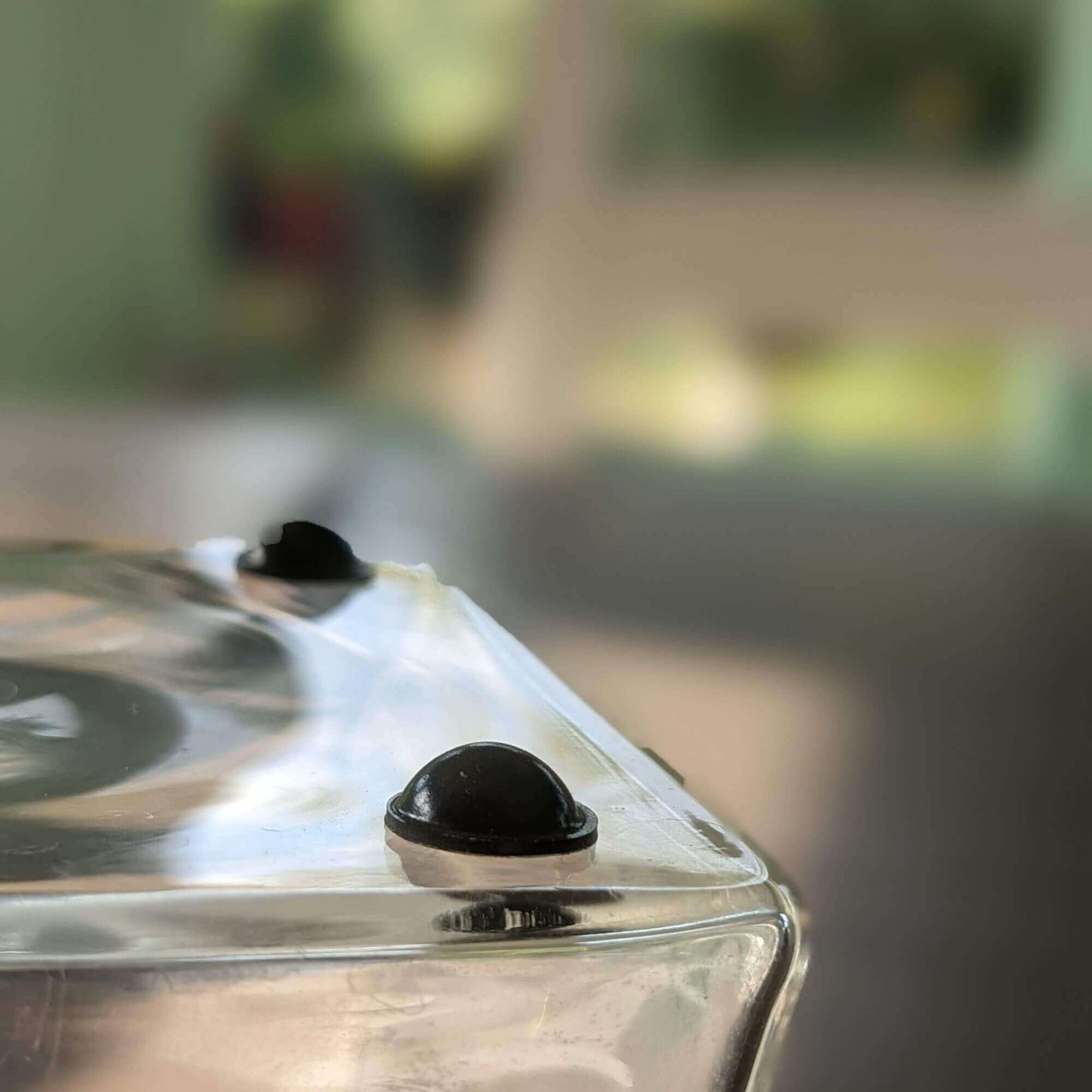 Black bumper feet being used on the base of a glass vase.