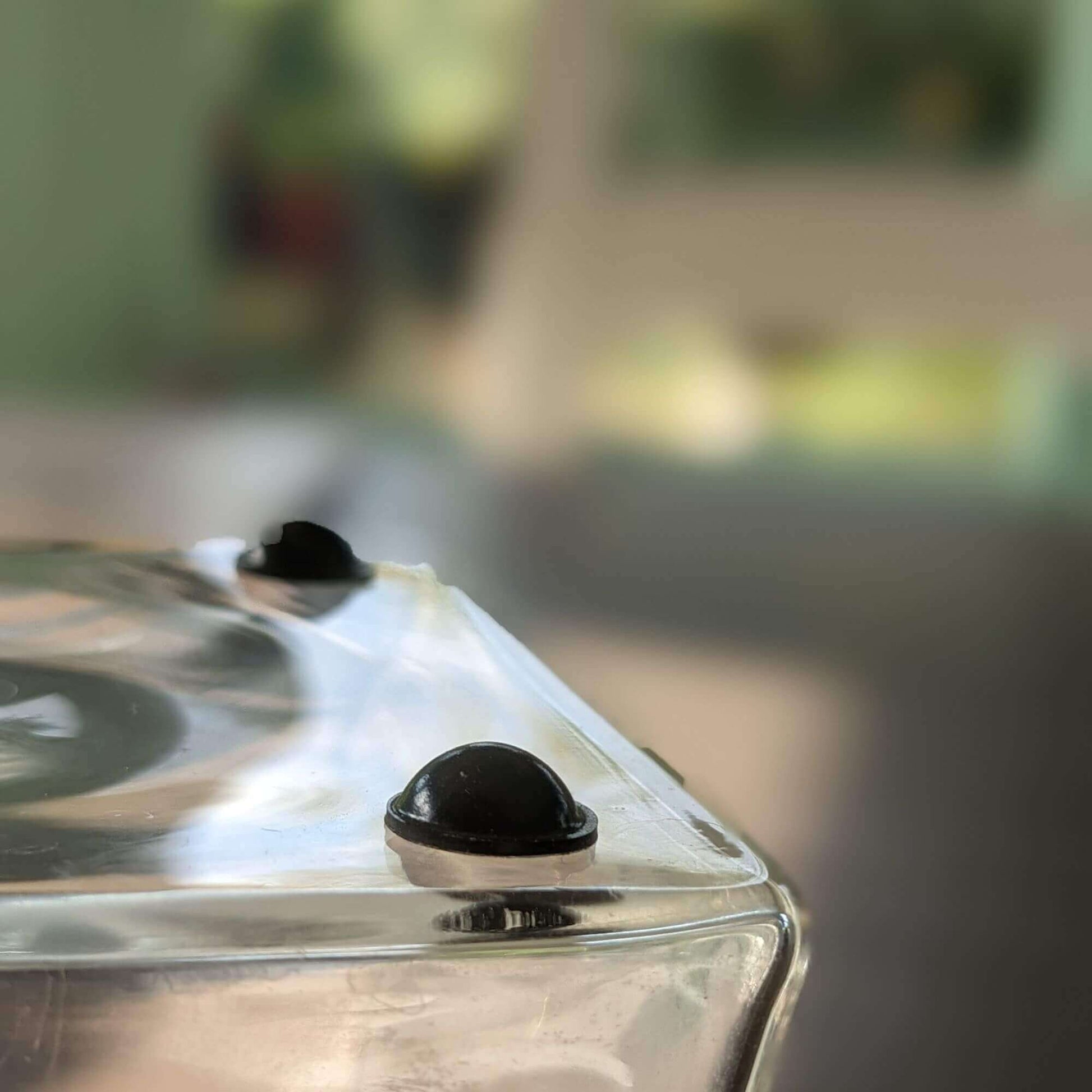 Black bumper feet being used on the base of a glass vase.