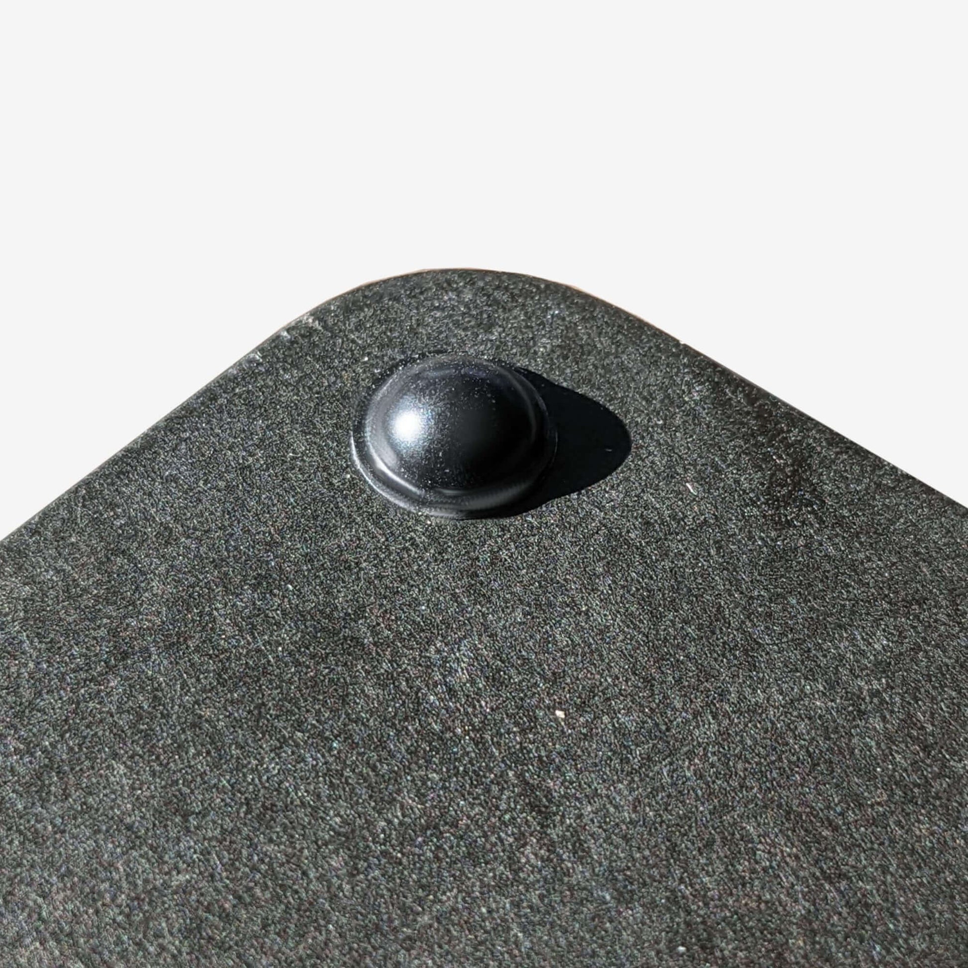 A black domed bumper used on the bottom of a cutting board to stop the board from slipping.