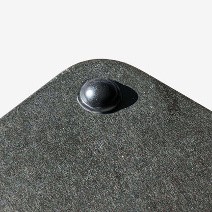 A black domed bumper used on the bottom of a cutting board to stop the board from slipping.