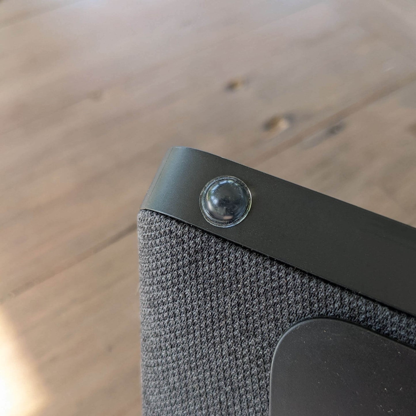 A clear domed bumper foot used on the base of a bluetooth speaker.