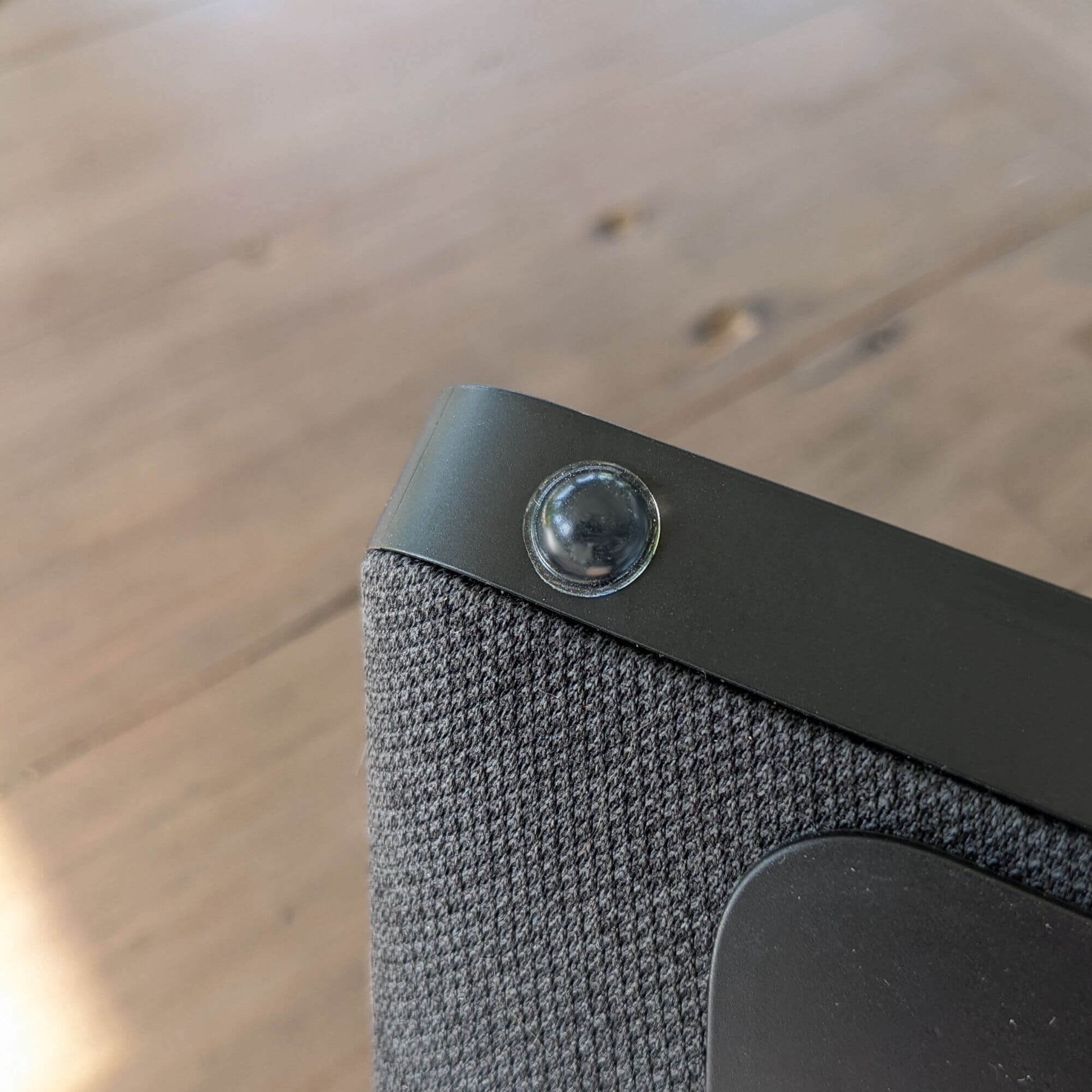 A clear domed bumper foot used on the base of a bluetooth speaker.