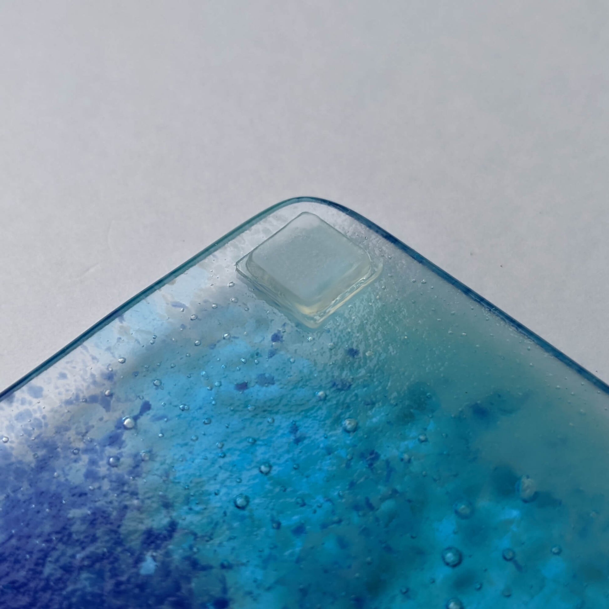 A square flat topped pad used on the base of a fused glass coaster.