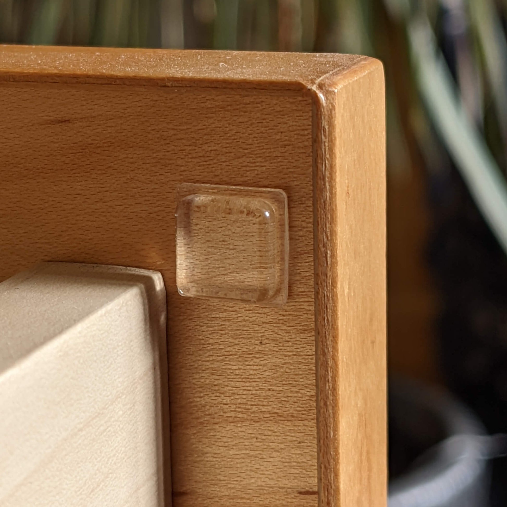 Square bumper pad used on the inside of a drawer to prevent noise when the drawer is closed.