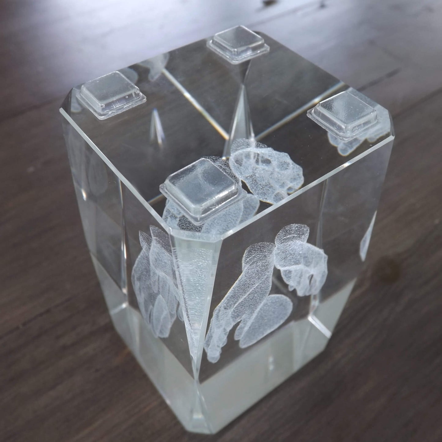 Four square flat topped bumper feet used on the base of a glass paperweight.