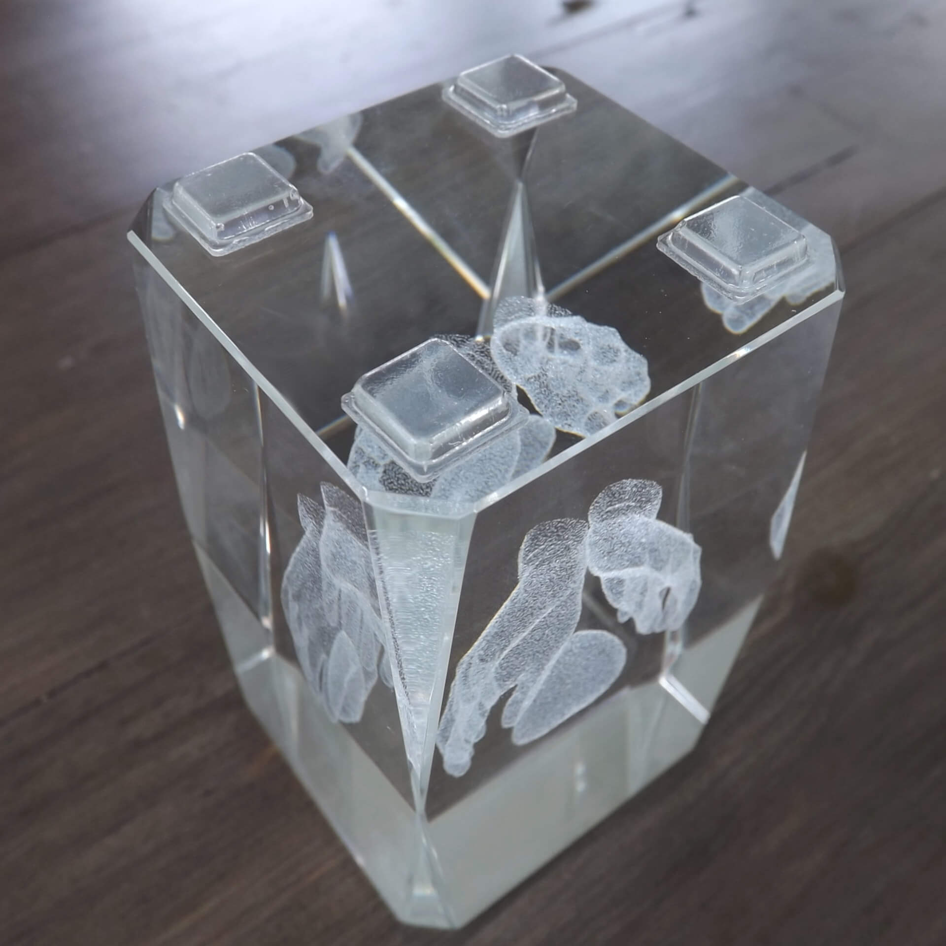 Four square flat topped bumper feet used on the base of a glass paperweight.