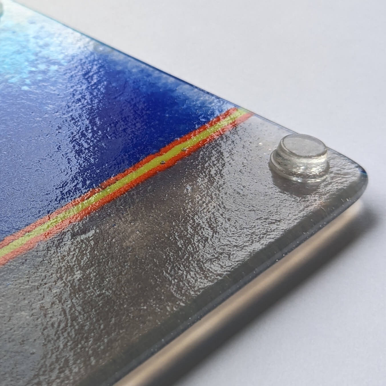 A clear flat topped bumper foot used on a glass coaster.