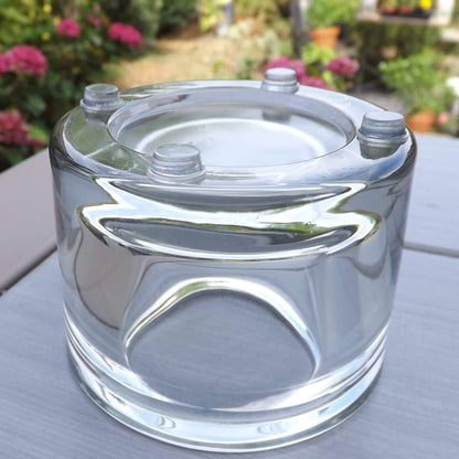 4 clear flat topped bumper feet used on the base of a clear glass tealight holder.