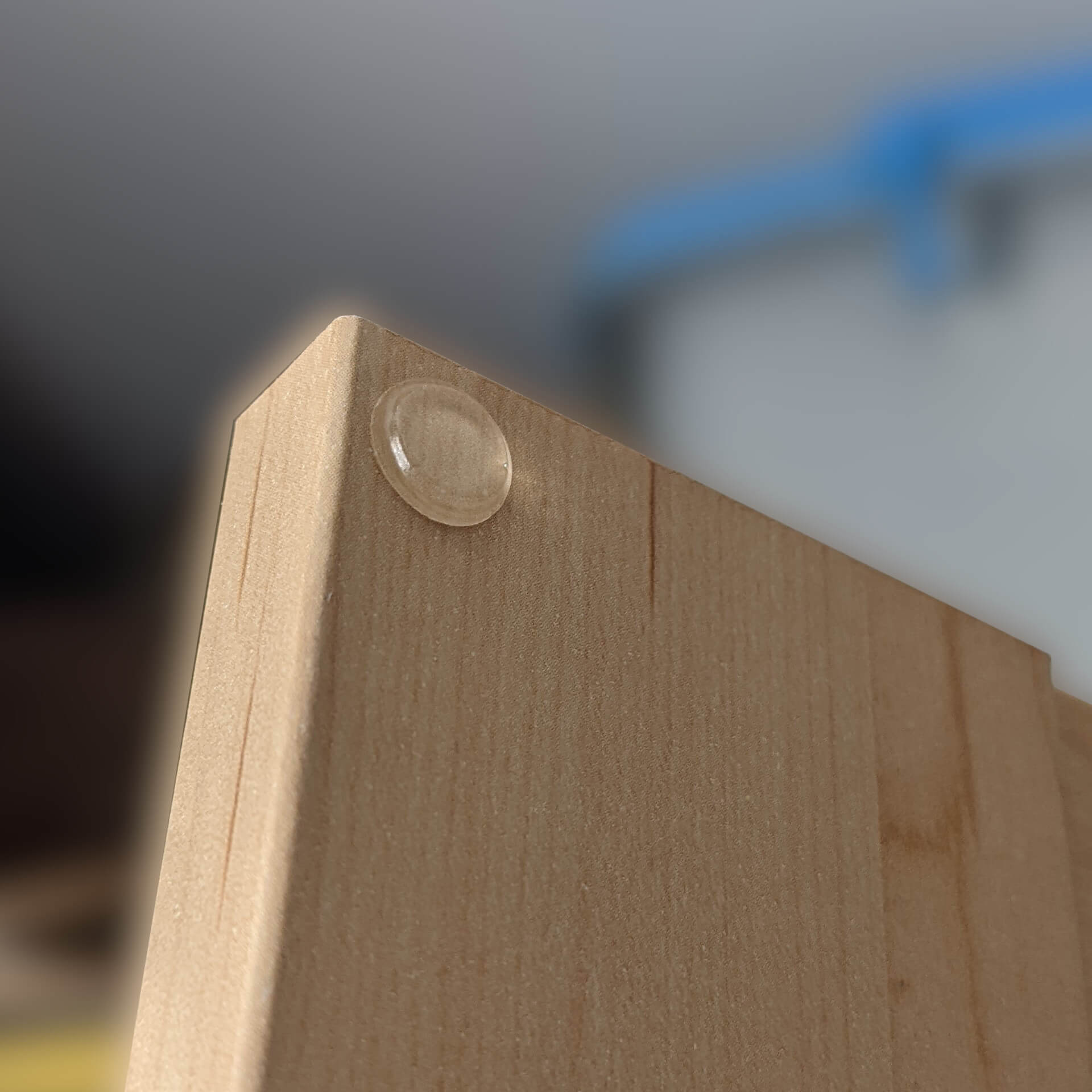 A clear flat bumper used on a cabinet door to prevent unwanted noise.