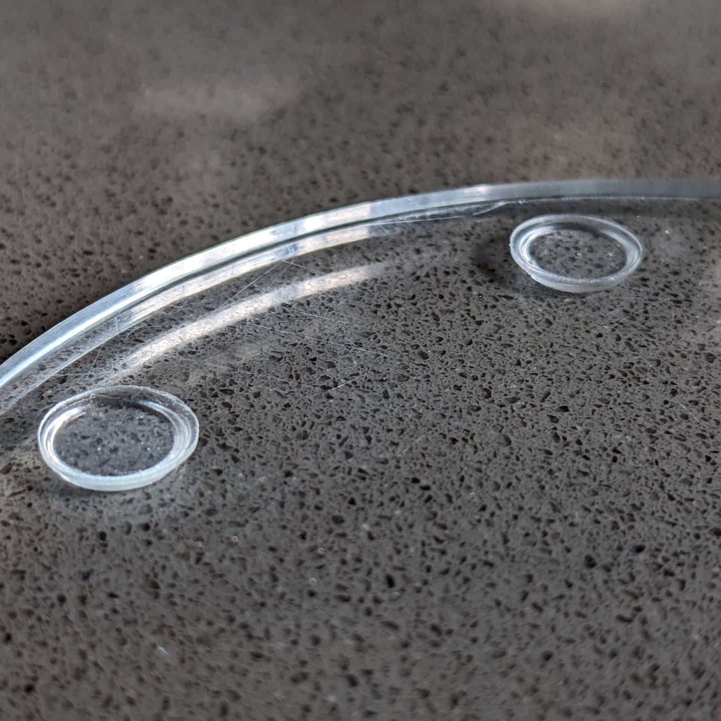 Bumper pads used as non-slip feet on a glass coaster.