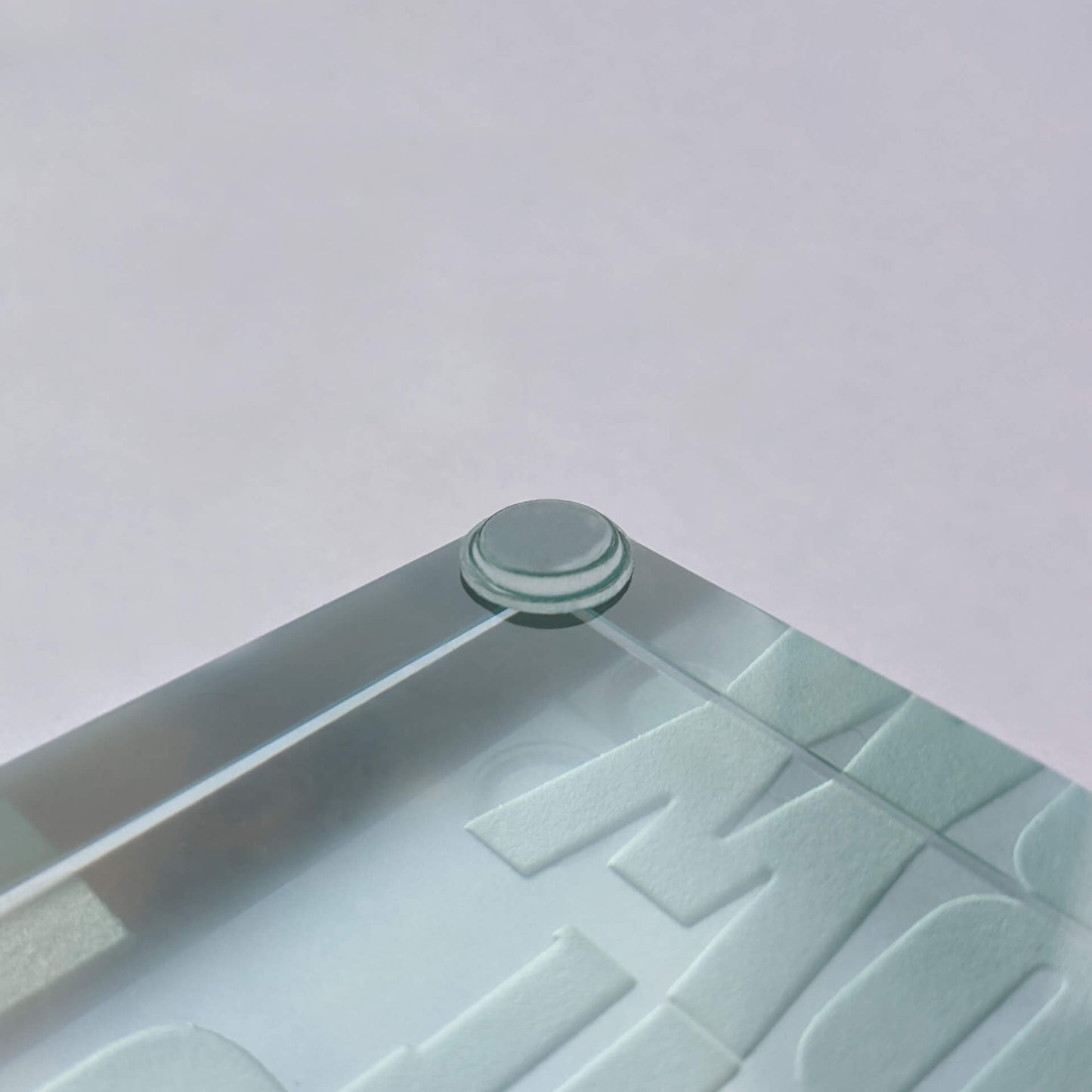 A flat topped bumper pad used on the edge of a glass paperweight.