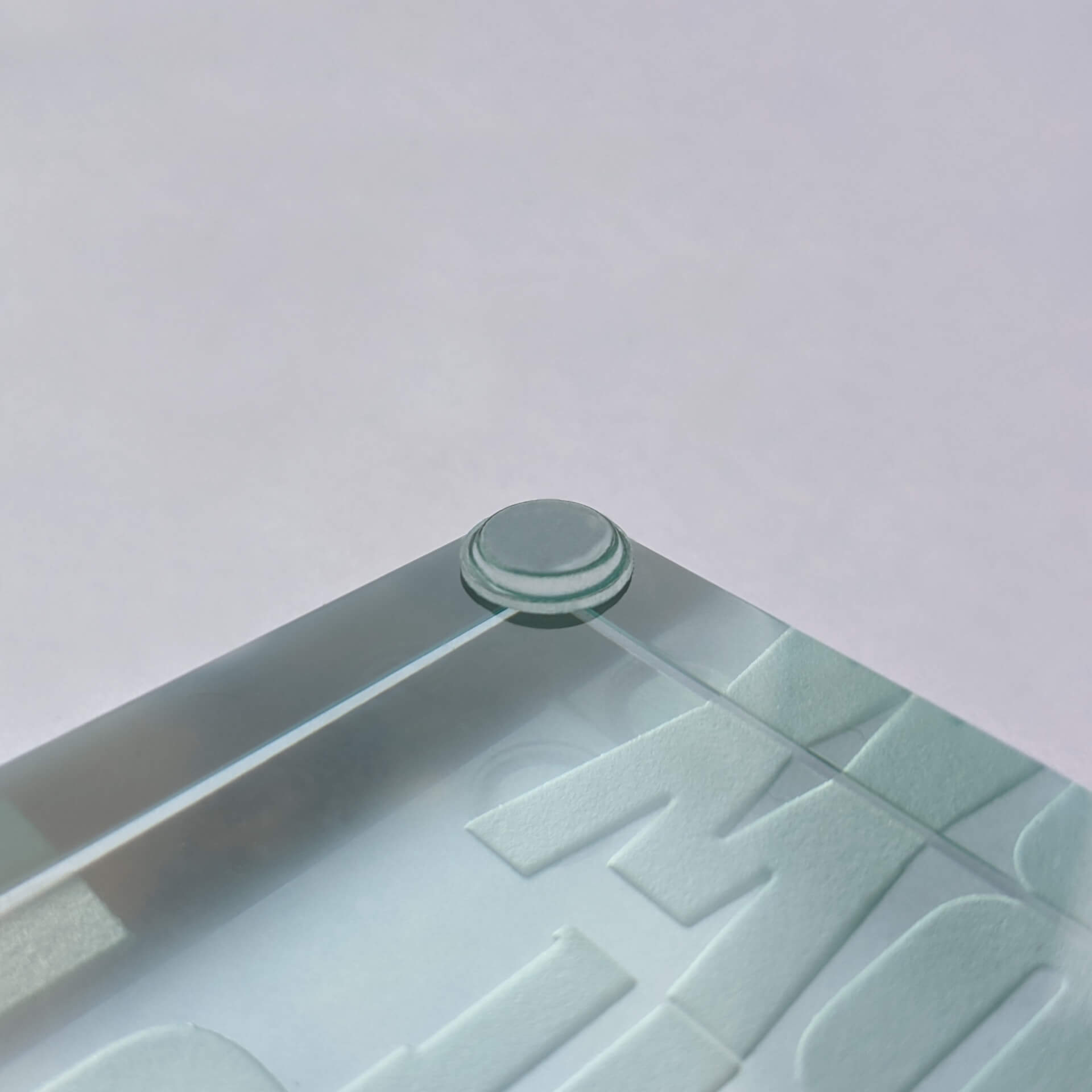 A flat topped bumper pad used on the edge of a glass paperweight.