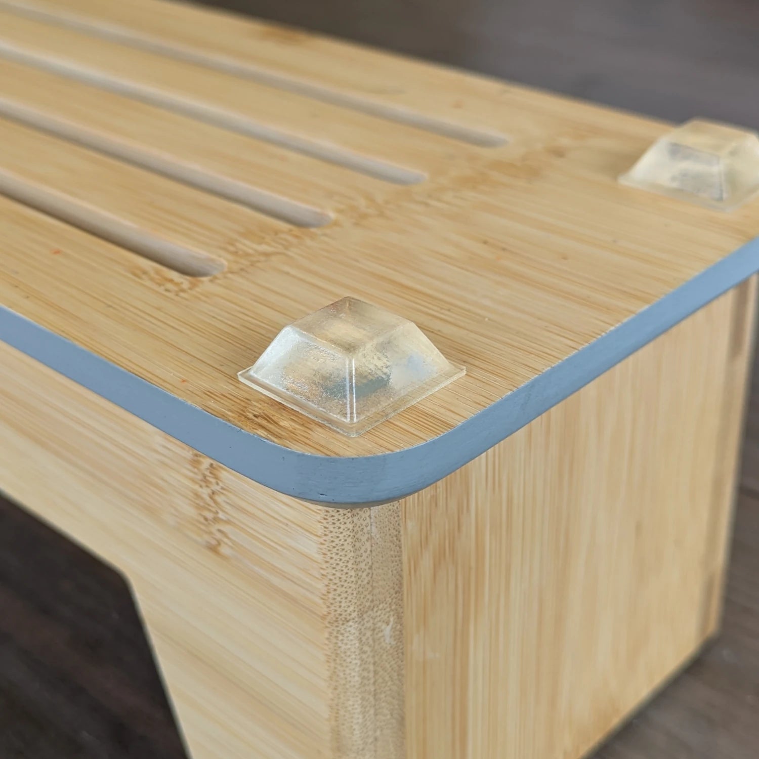 Chunky square flat topped bumper foot applied to a wooden chopping board rack base.