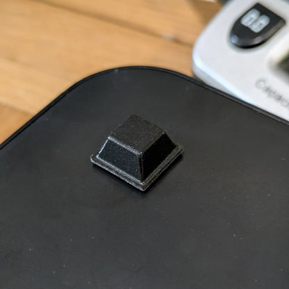 Black bumper on a plastic surface with a digital device in the background