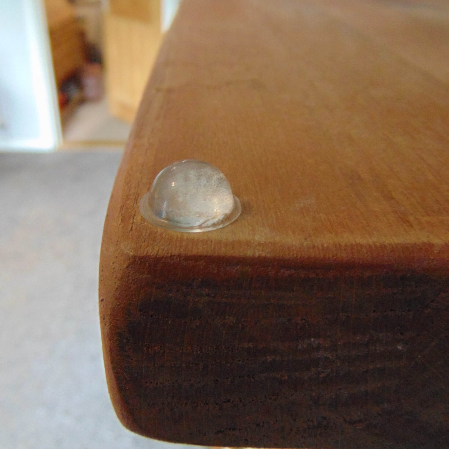 A domed bumper applied to a wooden sideboard.