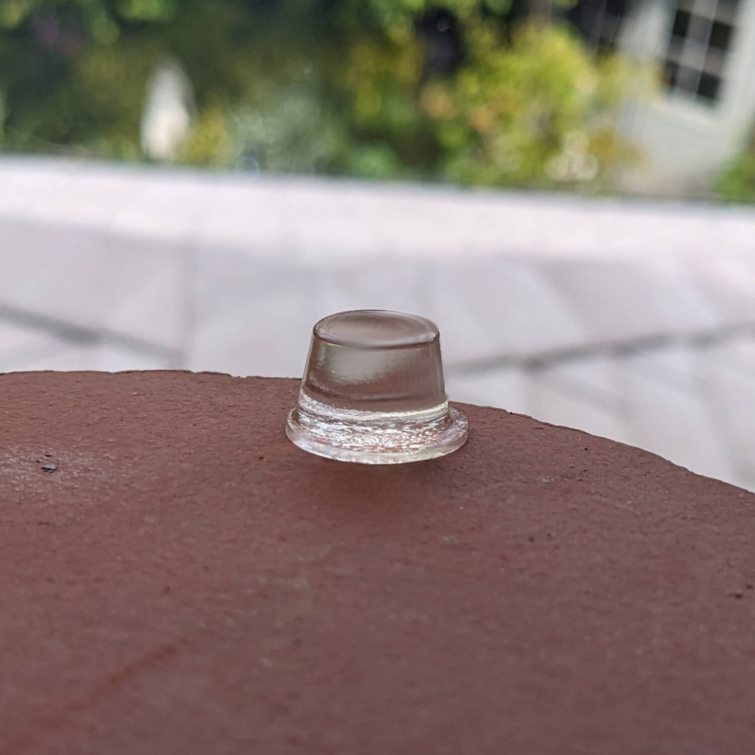 A clear bumper foot used on a smooth ceramic surface.