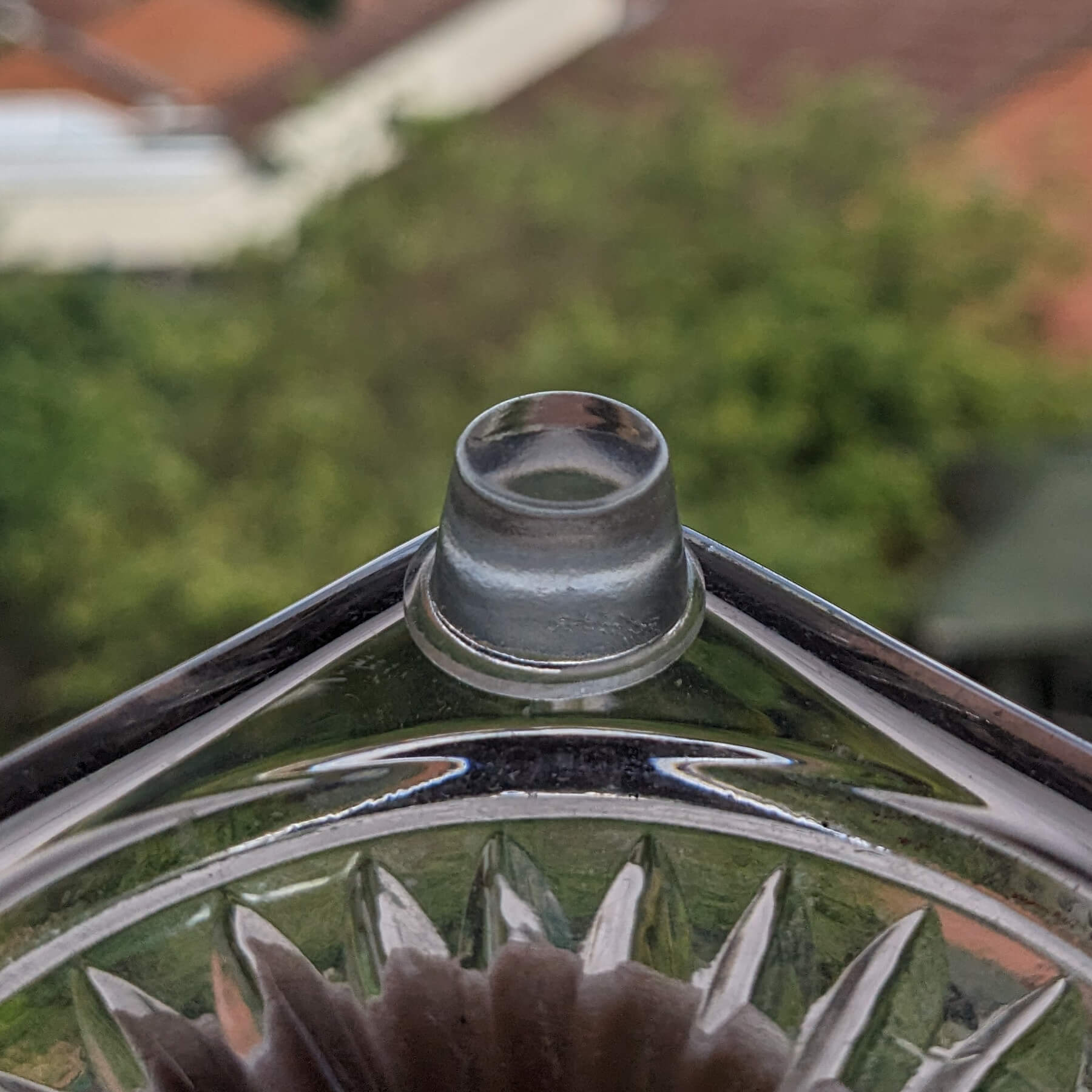 Clear flat bumper foot used on the corner of a glass candlestick holder.