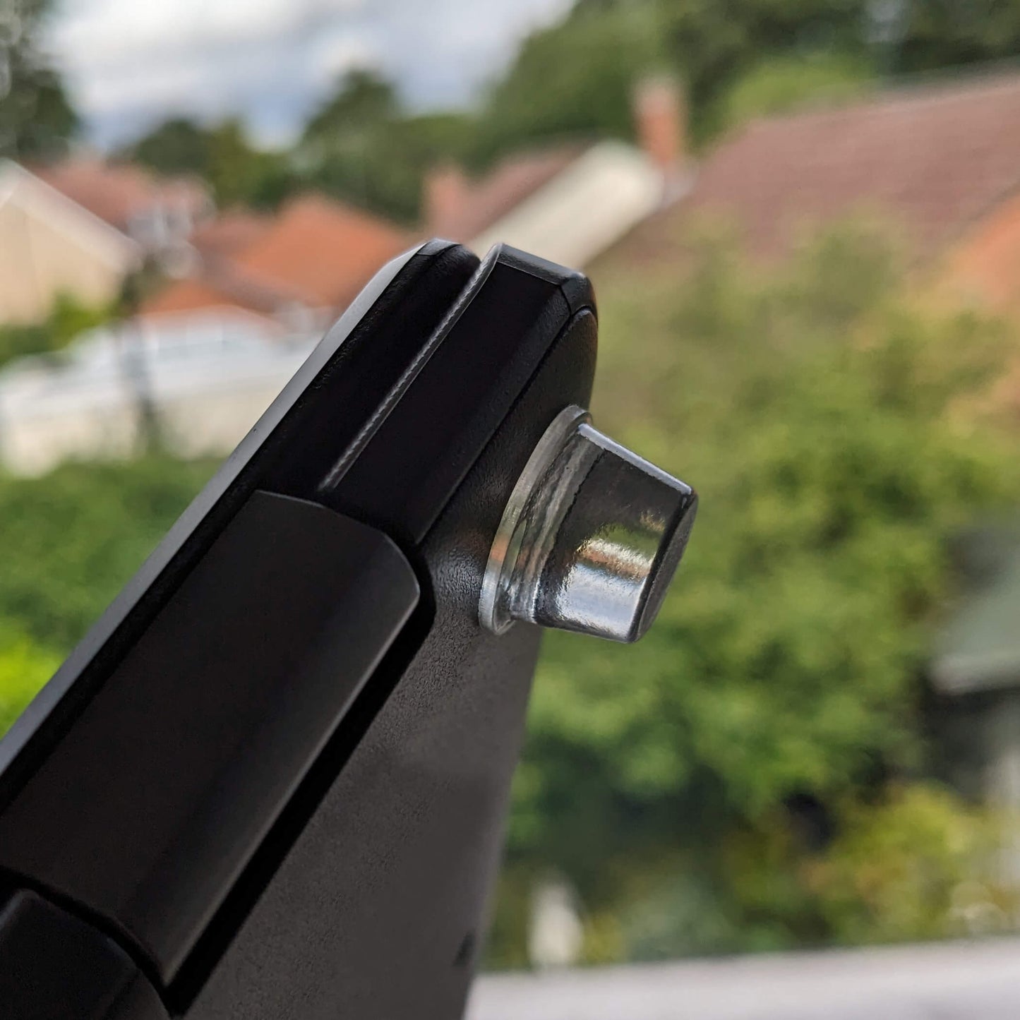 A clear bumper foot adhered to the corner of a laptop base.