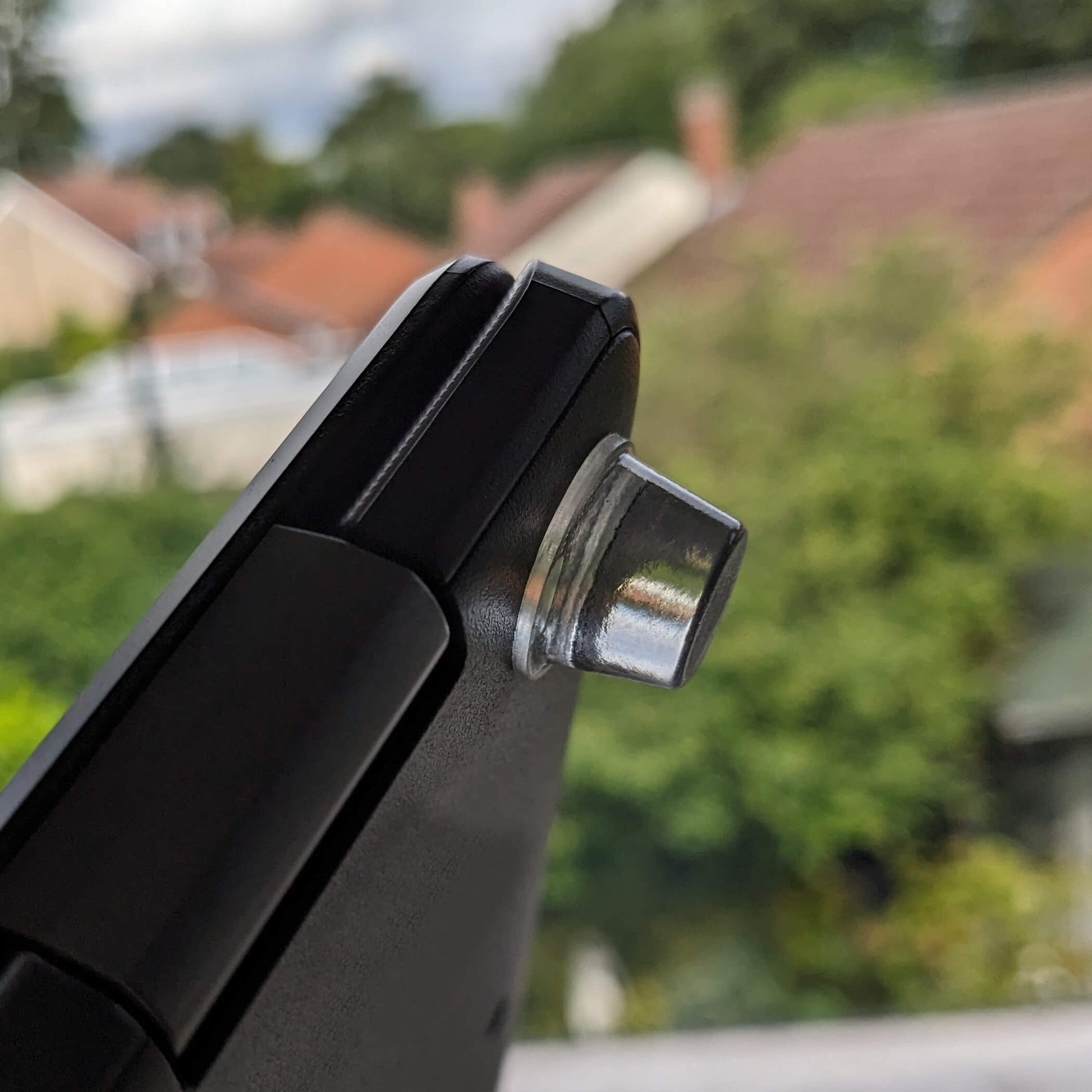 A clear bumper foot adhered to the corner of a laptop base.