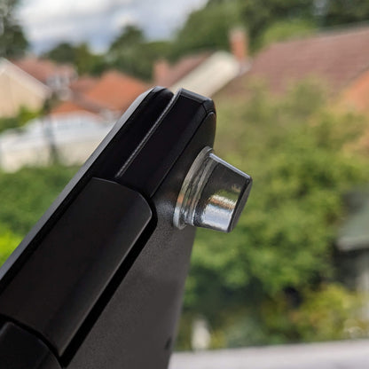 A clear bumper foot adhered to the corner of a laptop base.