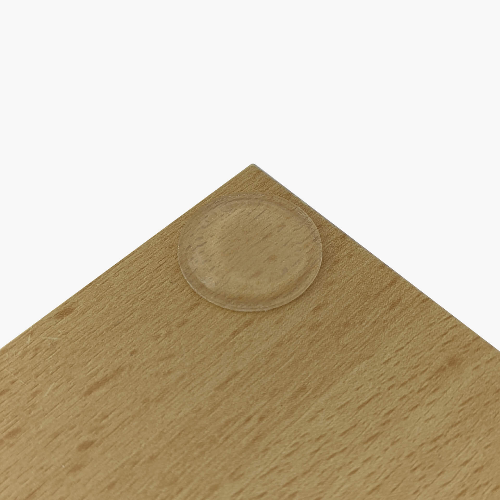 A low profile bumper pad used on the corner of a wooden chopping board.
