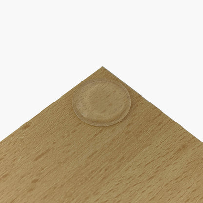 A low profile bumper pad used on the corner of a wooden chopping board.