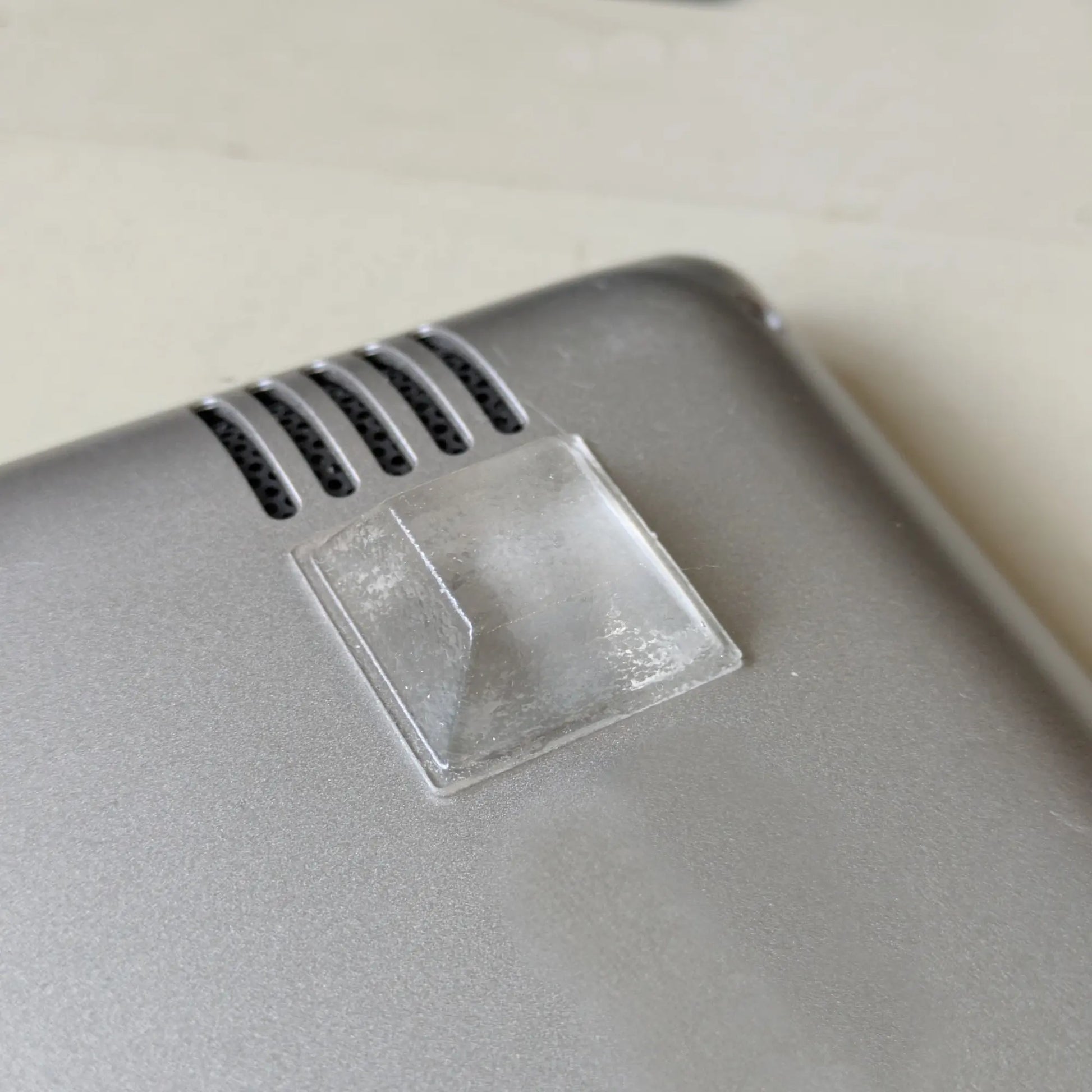 Close-up of a gray electronic device with a clear bumper affixed to the base