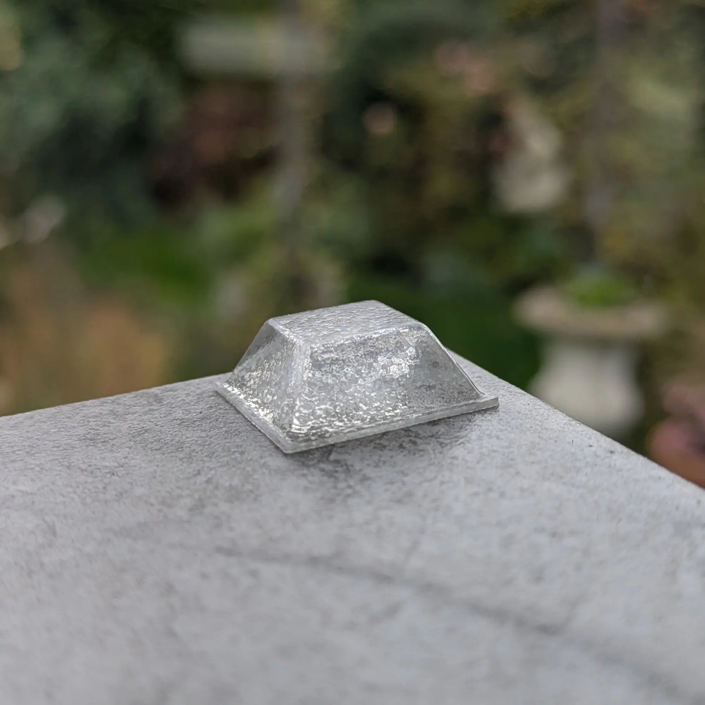 Clear square bumper foot on a stone surface with a blurred natural background