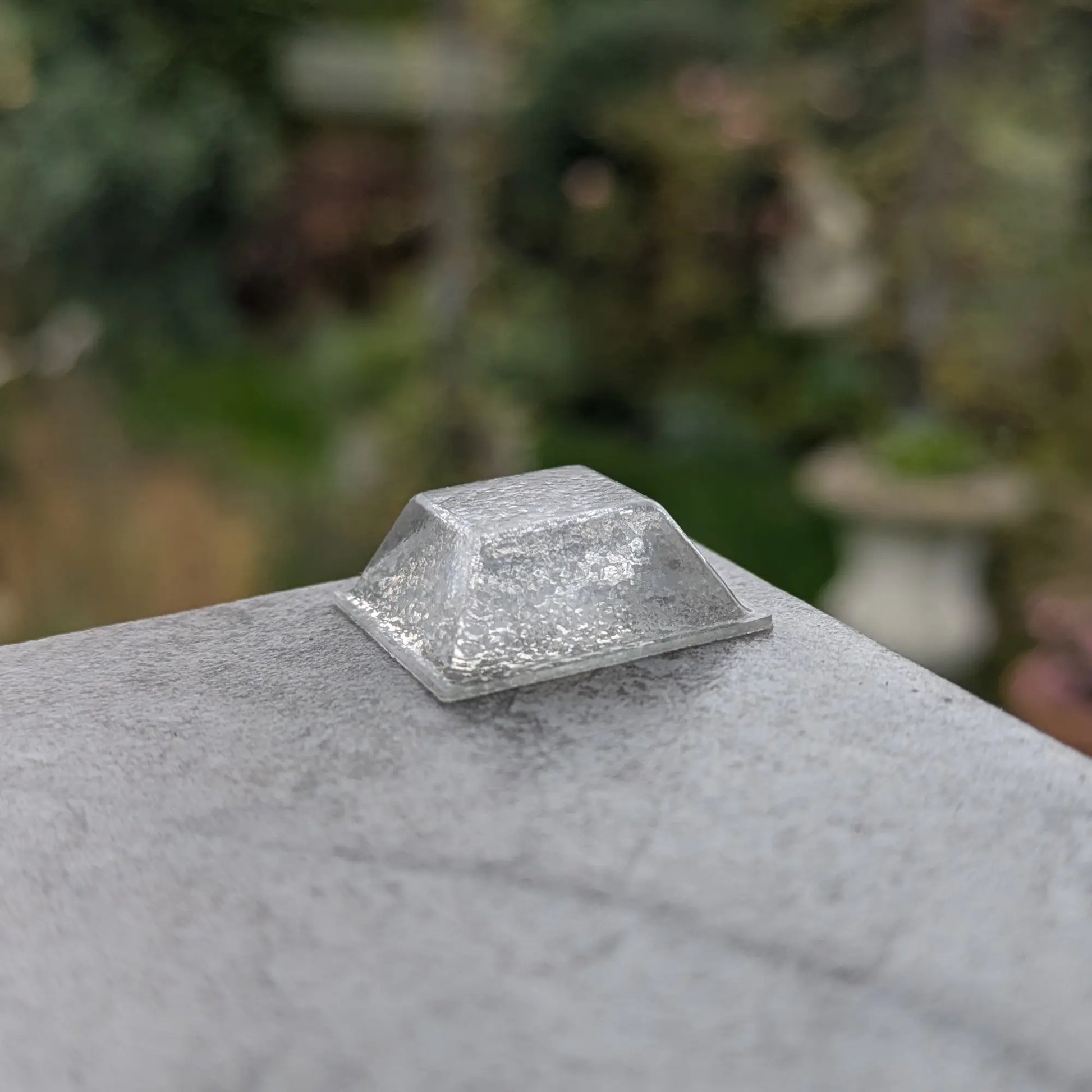 Clear square bumper foot on a stone surface with a blurred natural background